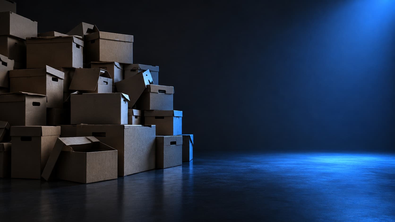 Pilha de caixas de arquivo de papelão à esquerda e, à direita, um espaço limpo e vazio iluminado de azul.